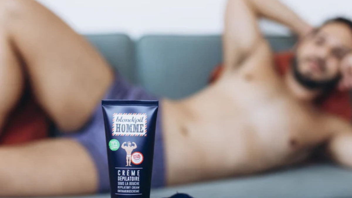 Un homme allongé en arrière-plan, mettant en avant un tube de crème dépilatoire pour homme au premier plan. Idéal pour illustrer les solutions d'épilation masculine avec des crèmes dépilatoires efficaces et adaptées.