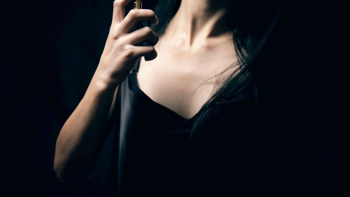 Femme vaporisant du parfum sur son cou pour exprimer sa personnalité à travers une signature olfactive